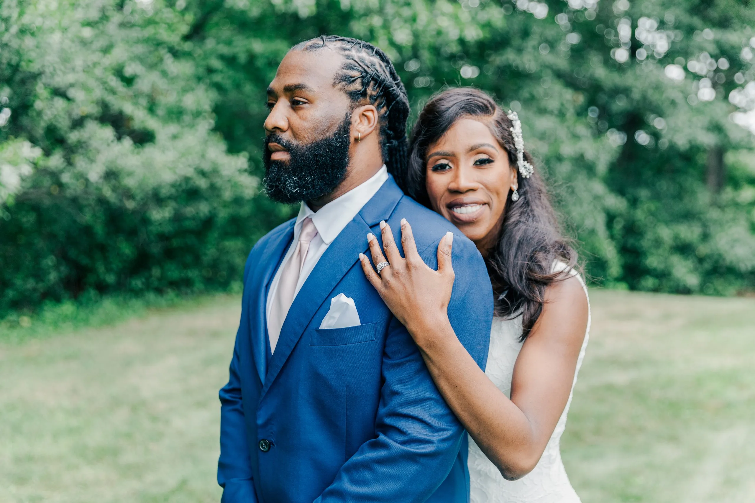 Bride and groom in a green New England field, editorial color photograph